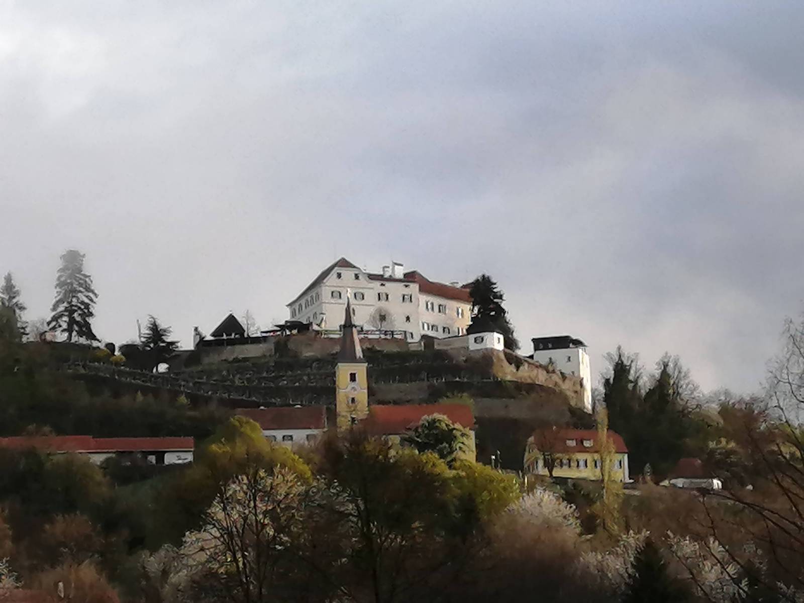 Schloss Kapfenstein hoch über dem Ort Schloss Kapfenstein gesäumt von Weinbergen in mystischer Stimmung
